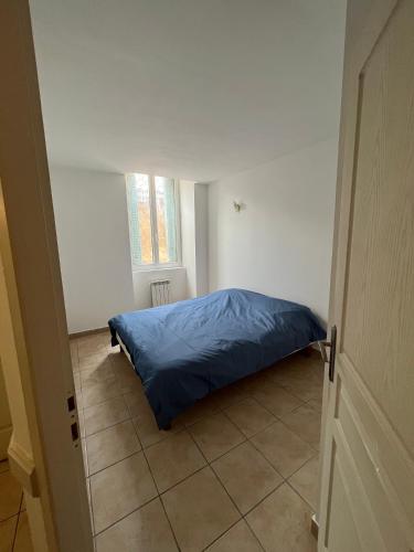 - une chambre avec un lit et une couverture bleue au sol dans l'établissement Appartement 4 personnes centre historique Aubenas, à Aubenas