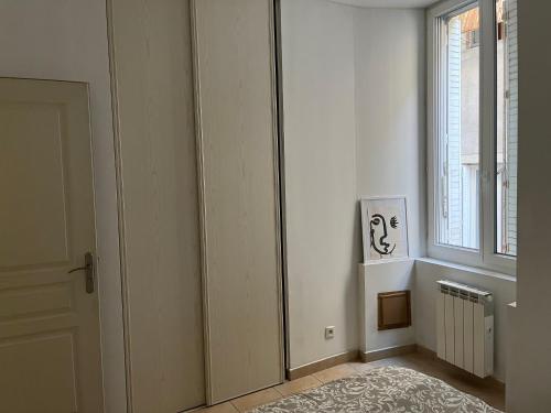 Cette chambre blanche dispose d'une porte et d'une fenêtre. dans l'établissement Appartement 4 personnes centre historique Aubenas, à Aubenas