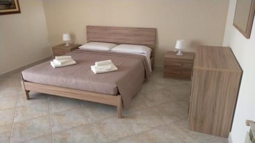 une chambre avec deux lits et deux tables de nuit dans l'établissement A Casa di Sarina, à Riposto