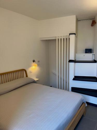 a bedroom with a white bed and a dresser at Nicolina 5 Il Cappero in Vernazza
