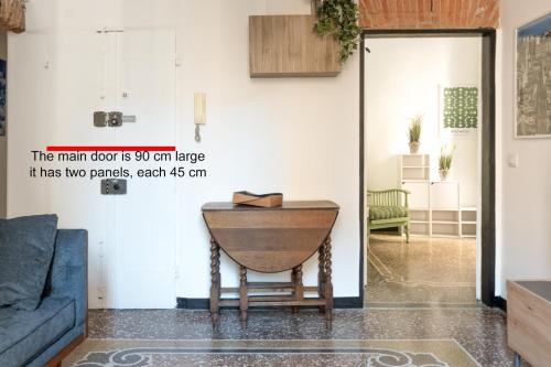 una sala de estar con una mesa y un sofá en Designer apartment in the center of Genoa, en Génova
