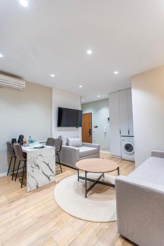 a living room with a couch and a table at Keslin Premium Seaside Apartments in Vlorë