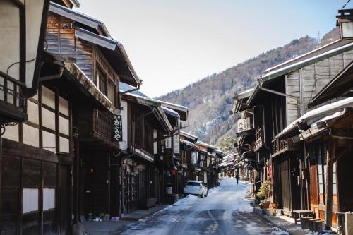 a car driving down a street next to buildings at LA TERRA narai in Shiojiri