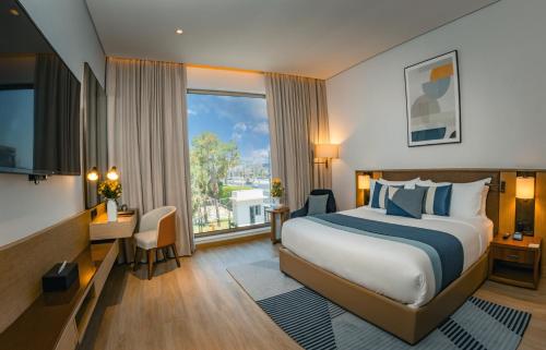 a hotel room with a bed and a large window at First Grand Hotel in Dammam