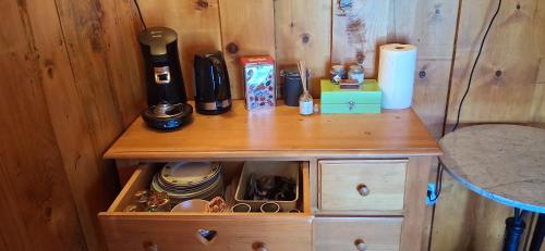 ein Holzschrank mit einer Kaffeemaschine darüber in der Unterkunft Chalet indépendant chez Aurèle in Dullin