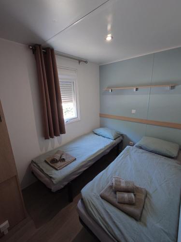 two beds in a small room with towels on them at Bellavista - Fishingcamp in Mequinenza