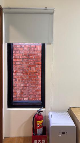 a window with a white roller blind in a room at 鹿厝老街民宿 in Lugang