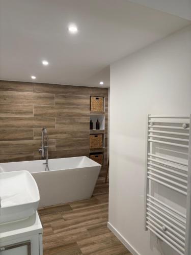 エマルグにあるMaison de standing proche de la merの白い浴槽と洗面台のあるバスルーム