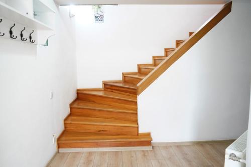 a staircase in a home with white walls and wooden floors at Hotel AKSU in Bucharest