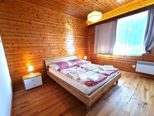 a bedroom with a bed in a wooden wall at Der Kristall by Globalimmoservice in Bad Kleinkirchheim