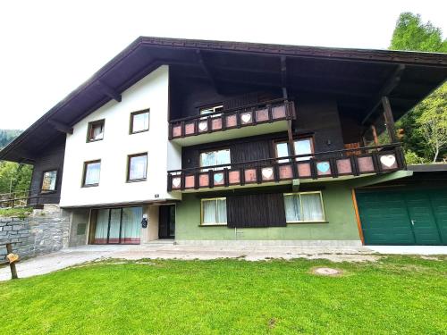 a large house with a balcony and a yard at Der Kristall by Globalimmoservice in Bad Kleinkirchheim
