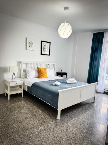 a bedroom with a bed with blue sheets and orange pillows at Pura Vida Mamaia Nord 2-vila exclusivista cu 3 apartamente individuale in Năvodari