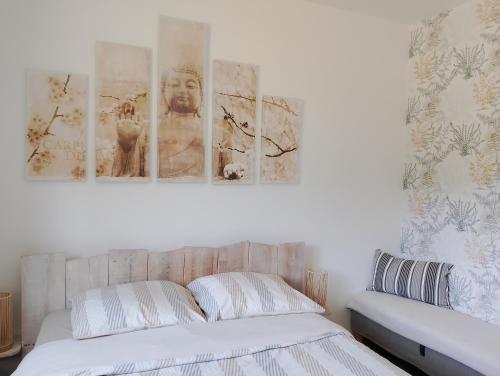 une chambre avec un lit avec trois tableaux au mur dans l'établissement Cosy au bassin, à La Teste-de-Buch