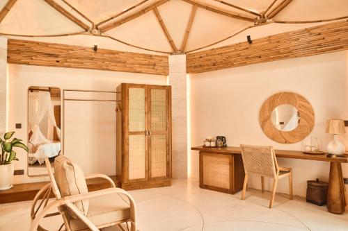 a room with a table and chairs and a mirror at Nuanu Suites & Accommodations in Tabanan