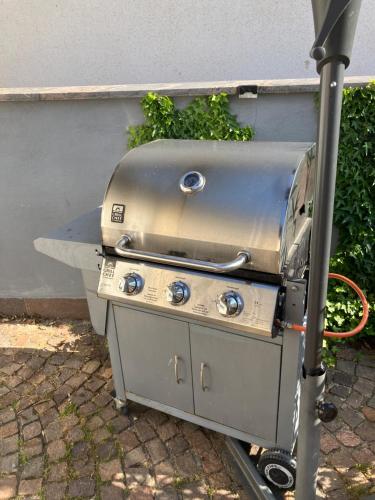 a grill sitting on the ground next to a wall at Ü Villa Single Apartment mit Grillmöglichkeit in Hirschaid