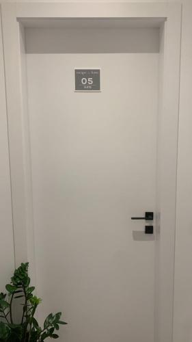 a door with a sign on it next to a plant at Escape Suites in Dhërmi