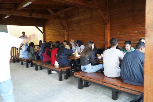 a group of people sitting on benches in a restaurant at Hotel AKSU in Bucharest