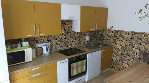 a kitchen with yellow cabinets and a stove top oven at Penzion Zelená zahrada in Kladenské Rovné