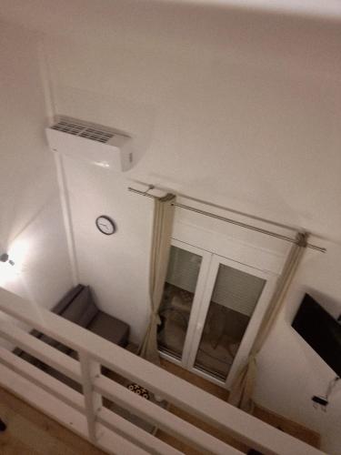 a room with a staircase with a window and a tv at SmallHouseLefkada ΘΕΜΑ in Lefkada Town
