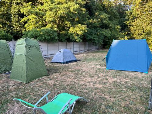 deux tentes et une chaise dans une cour dans l'établissement Nature & Camping, à Cepoy