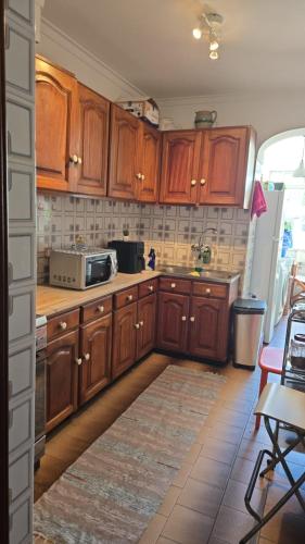 a kitchen with wooden cabinets and a microwave at Mk house in Estoril
