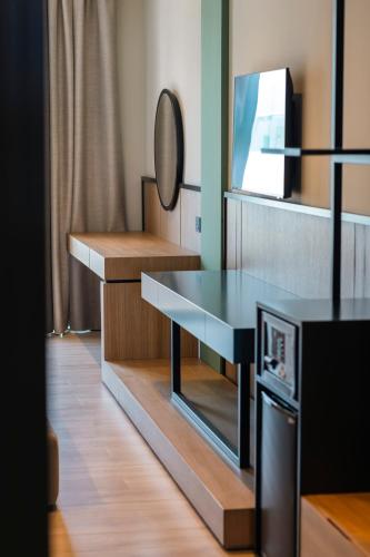 a room with a table with a mirror and a tv at Green Light Hotel in Ksamil