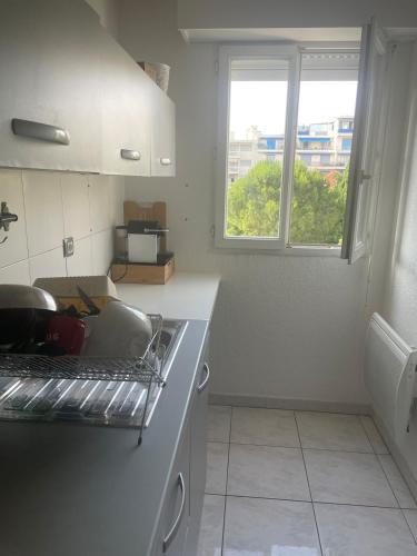 une cuisine avec un évier et une fenêtre dans l'établissement Sun and Sand, à Antibes