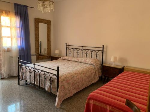 a bedroom with a bed and a mirror and a window at Casa tra gli ulivi a Motta San Giovanni vacanza in Reggio Calabria in Motta San Giovanni