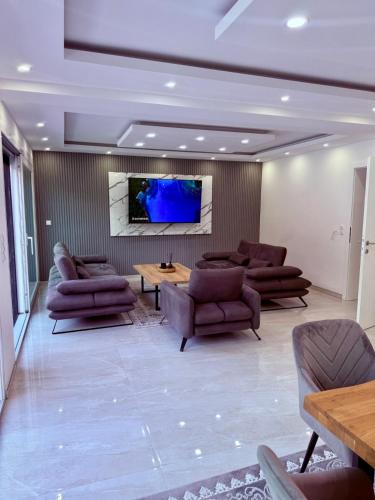 a living room with couches and a tv on a wall at Villa La Casa Del Sol in Srebrenik
