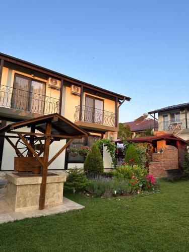 a house with a balcony on top of a yard at Casa George in Costinesti