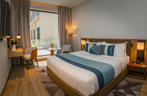 a hotel room with a large bed and a window at First Grand Hotel in Dammam