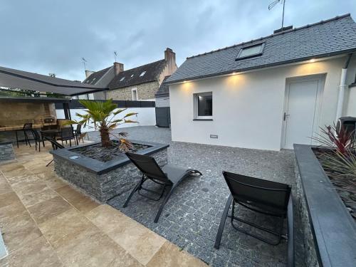 a patio with two chairs and a fire pit at Logement thérapie bien-être in Pont-lʼAbbé