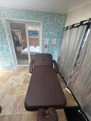 a bench in a room with a bed and a mirror at Logement thérapie bien-être in Pont-lʼAbbé