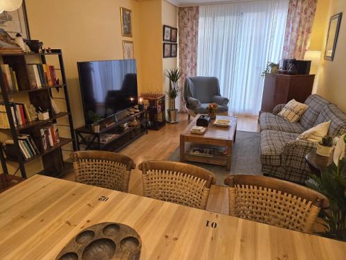 a living room with a table and chairs and a television at Apartamento turístico Aguere in Ribadesella