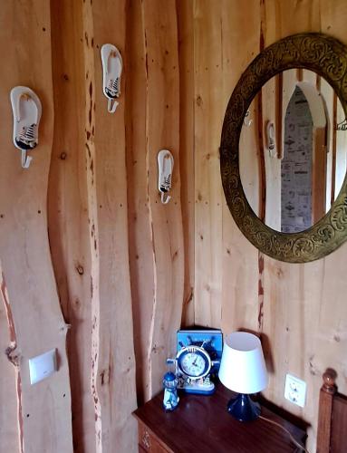 a clock on a table with a mirror and a lamp at Imantass in Salacgrīva