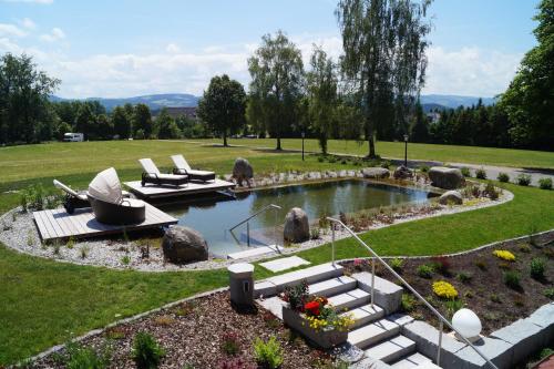 a garden with a pond in the middle of a field at Hotel Gasthof Jägerhaus in Sankt Peter