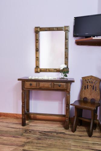 a wooden dressing table with a mirror and a chair at Café Bar Hotel Jefi in Jaraiz de la Vera