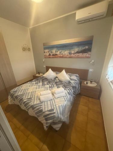a bedroom with a bed and a painting on the wall at La Casetta di Elena in LʼAmericano