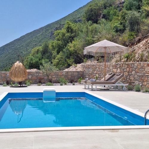 a swimming pool with a bench and an umbrella at Azzurro Mare in Póndi