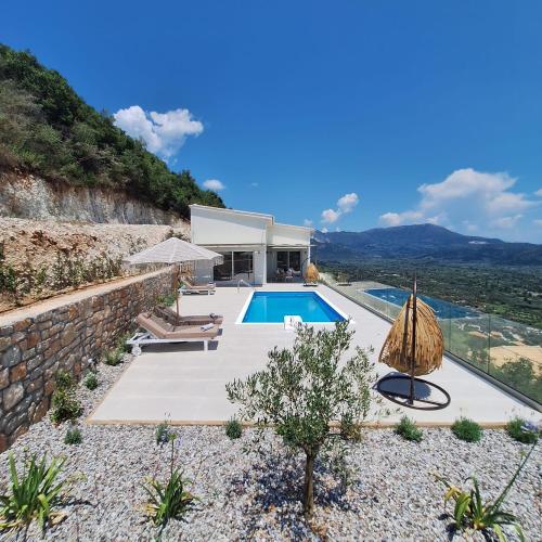 a villa with a swimming pool and a house at Azzurro Mare in Póndi