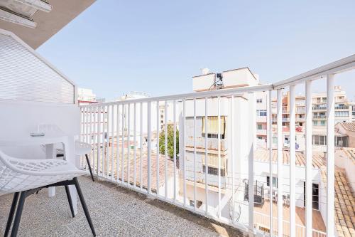 a balcony with a white chair and a building at SB Arenal in El Arenal