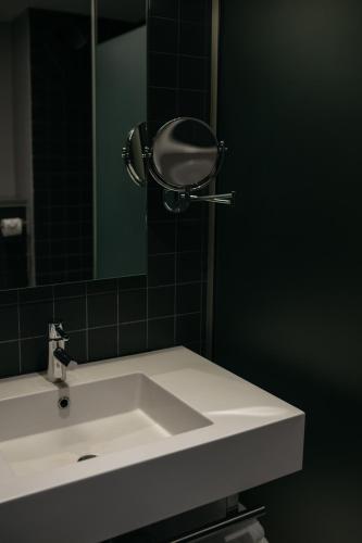 a bathroom with a white sink and a mirror at La Butte in Plouider
