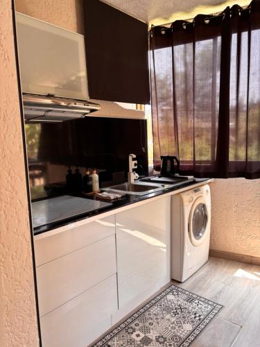 une cuisine avec une machine à laver et un lave-linge dans l'établissement Bandol Studio, à Bandol
