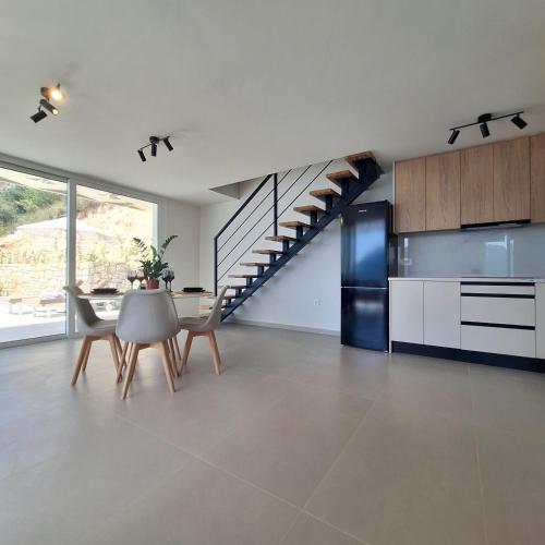 a kitchen with a staircase and a table and chairs at Azzurro Mare in Póndi