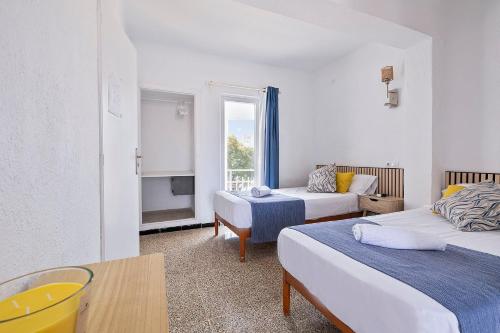 a hotel room with two beds and a window at SB Arenal in El Arenal