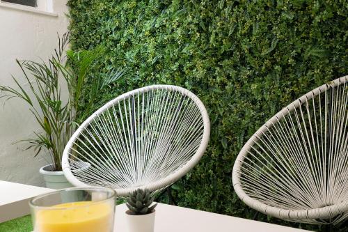 two white chairs on a table with a glass of orange juice at SB Arenal in El Arenal