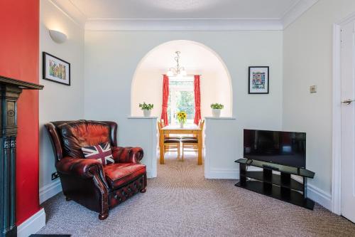 a living room with a chair and a television at 3 BR Property in Prestwich 15 mins from Manchester City Centre Garden Free parking Superfast WIFI Netflix in Manchester