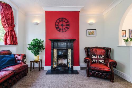 a living room with two chairs and a fireplace at 3 BR Property in Prestwich 15 mins from Manchester City Centre Garden Free parking Superfast WIFI Netflix in Manchester