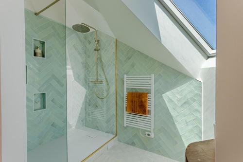 une salle de bain avec une douche avec une porte vitrée dans l'établissement Une parenthèse enchantée à Larmor-Baden, à Larmor-Baden