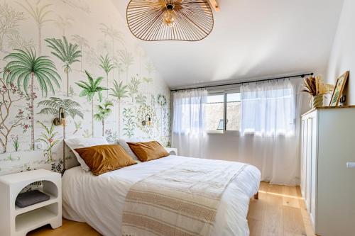 - une chambre avec un grand lit et du papier peint tropical dans l'établissement Une parenthèse enchantée à Larmor-Baden, à Larmor-Baden